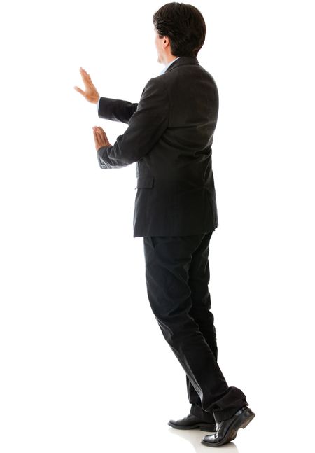 Rear view of a man pushing something - isolated over a white background